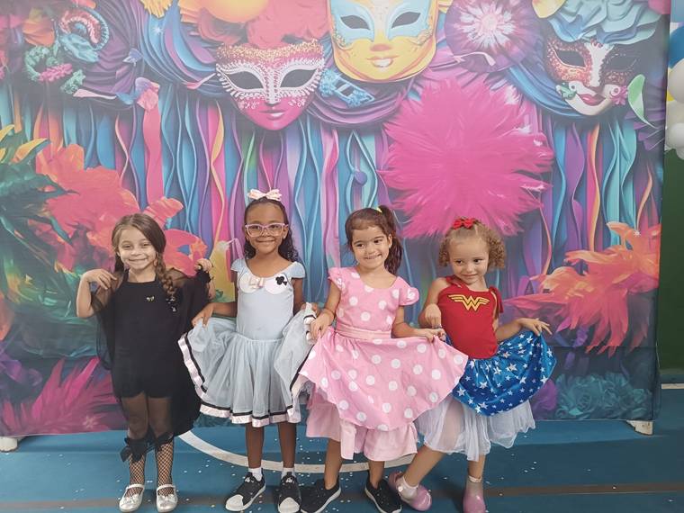 Alunas fantasiadas posando no painel de Carnaval da Creche Escola Santa Beatriz