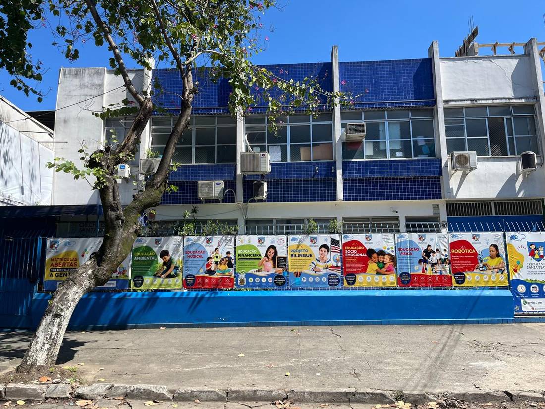 Fachada da Creche Escola Santa Beatriz na Rua Samuel das Neves, com os banners das atividades no muro