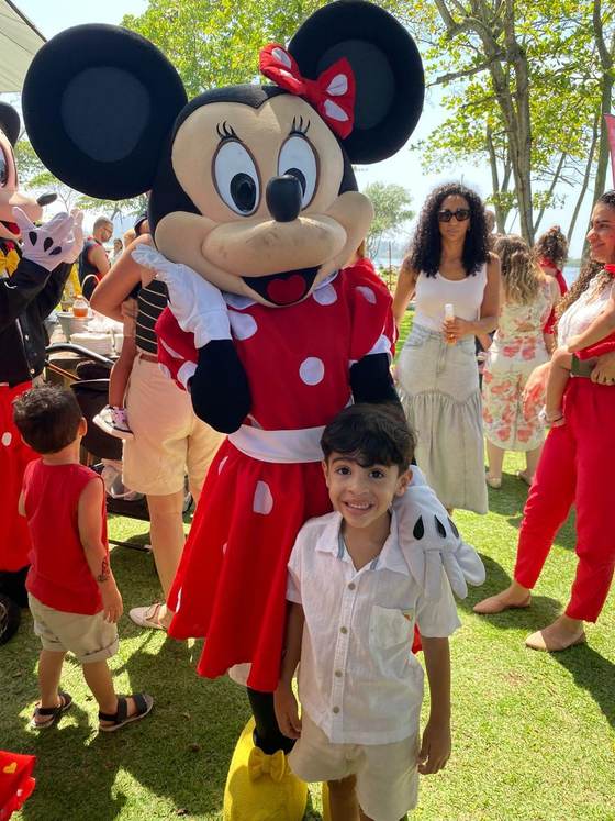 Aluno da Creche Escola Santa Beatriz ao lado de um personagem na Festa da Família