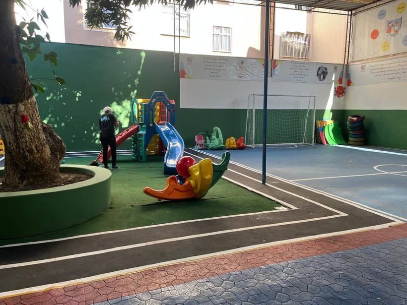 Pátio da escola com playground, quadra e área verde